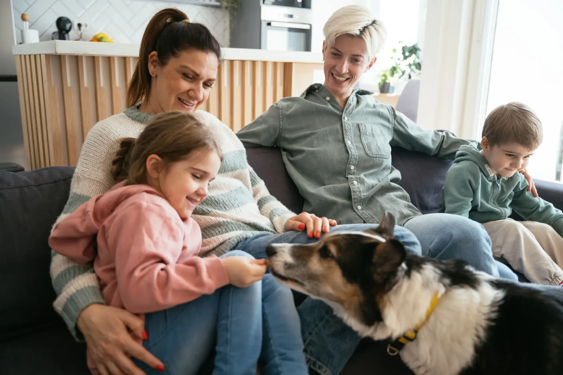 Family enjoying time with their dog indoors.