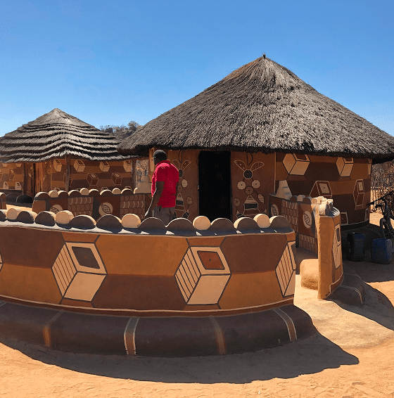 Person outside decorated round hut