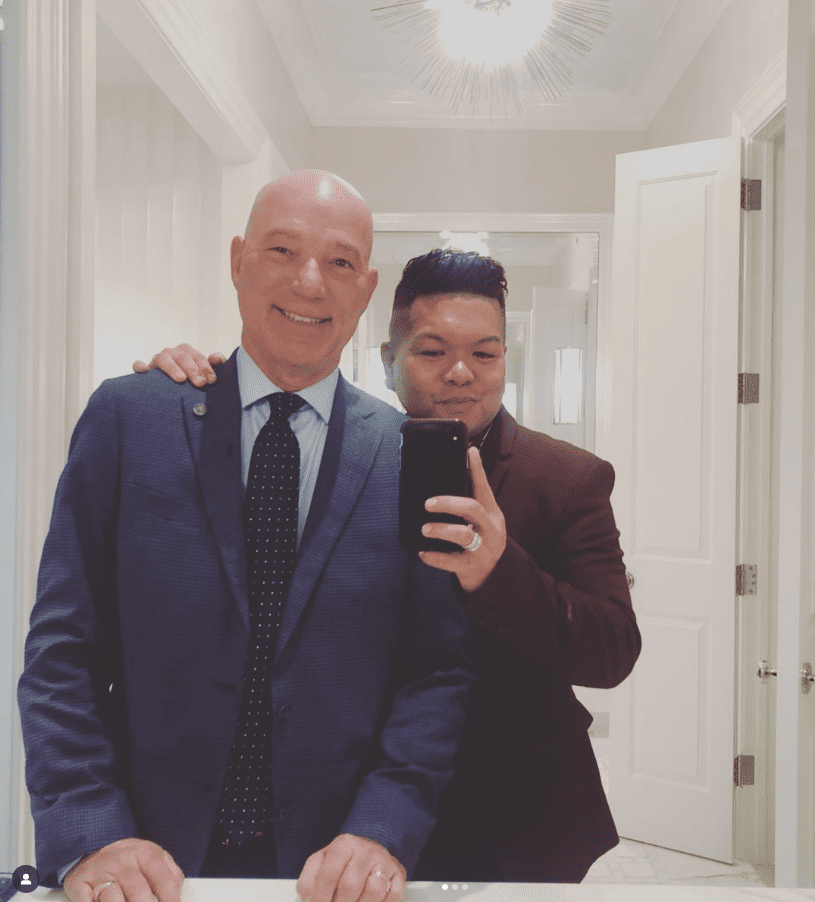 Two men posing for a selfie in a well-lit room.